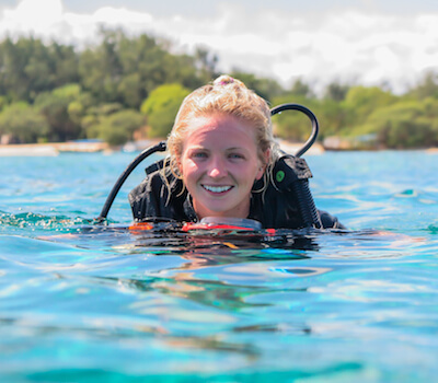 Smiling divemaster on the surface after a dive